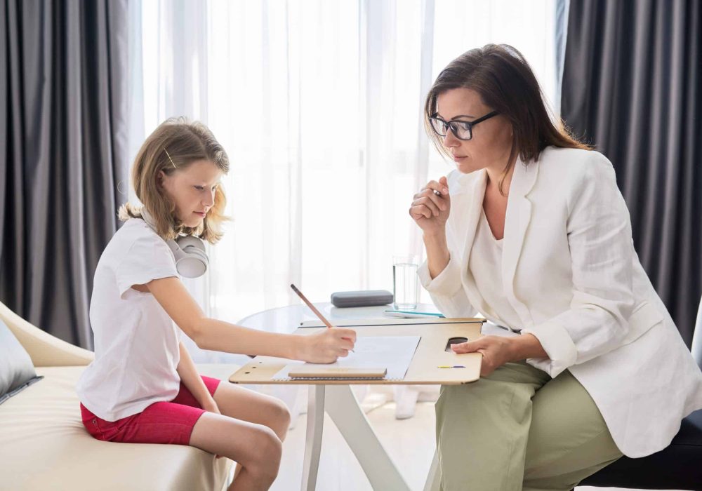 Child psychologist talking to girl kid in office